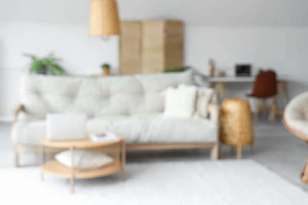 Pohled na rozmazaný obývací pokoj s pohovkou a notebookem na stole - Fotografie, Obrázek