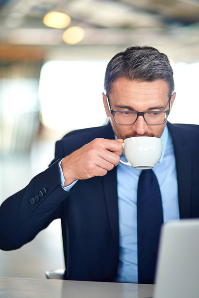 Businessman, laptop and drinking coffee or finance research with morning email, project planning or office. Male person, networking and tech entrepreneur or company founder, caffeine or connectivity. - Photo, Image