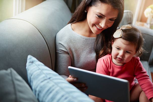 Happy, sohva ja äiti vauvan kanssa tabletilla online-pelejä, videoiden katselua ja elokuvien suoratoistoa. Perhe, koti ja äiti nuori tyttö digitaalisen teknologian sarjakuvia, liimaus ja rentoutua yhdessä. - Valokuva, kuva