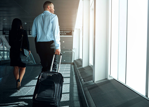 Travel, suitcase or luggage with business man in airport walking to gate for international trip or adventure. Corporate journey, male person or entrepreneur departure for global opportunity back view. - Photo, Image