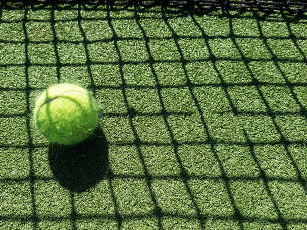  tennisbal terug lichte schaduw op tennisgras baan goed voor de achtergrond. Hoge kwaliteit foto - Foto, afbeelding