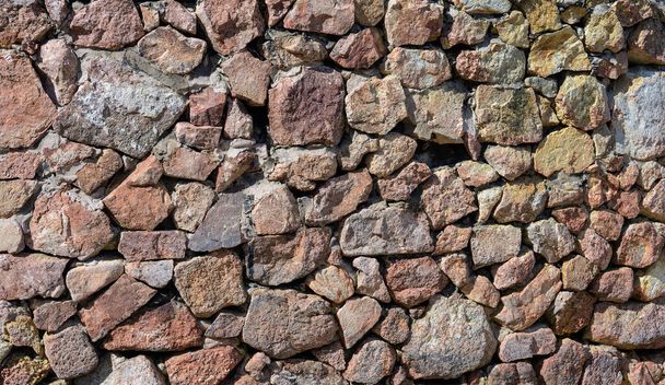 Фон каменной стены, построенный из различных форм и размеров и смонтированный вместе для создания прочной и стабильной структуры. - Фото, изображение