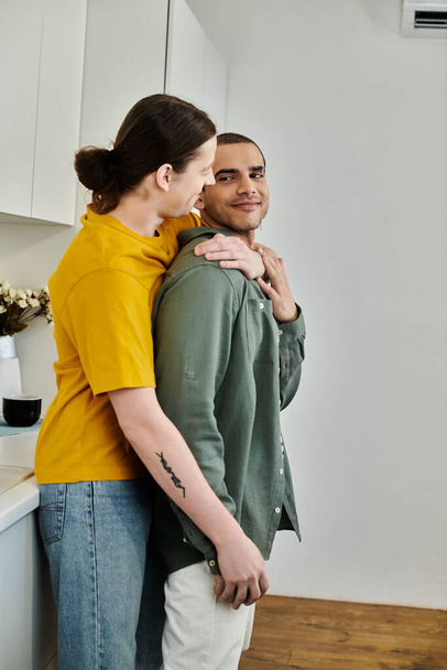 Молодая гей-пара делится нежным моментом в своей современной квартире. - Фото, изображение