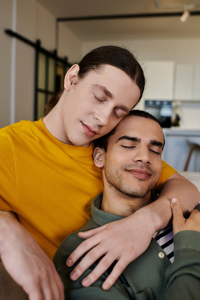 Een jong gay paar geniet van een rustig moment samen in hun moderne appartement. - Foto, afbeelding