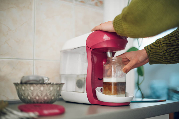 Mulher mãos ao usar máquina de café expresso em casa na cozinha. Café da manhã em casa. Processo de preparação de um café. - Foto, Imagem