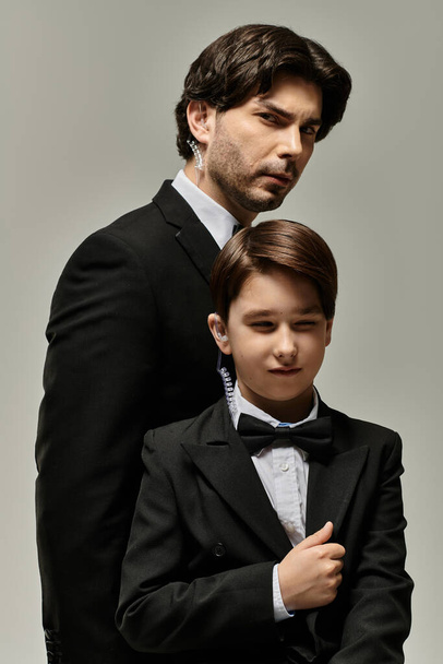 Πατέρας και γιος με ταιριαστά κοστούμια, μια στιγμή ήσυχου δεσίματος.. - Φωτογραφία, εικόνα