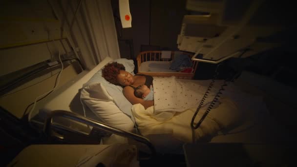 Fiatal afrikai anya fekszik kórházi ágyban gazdaság újszülött baba születése után - Felvétel, videó