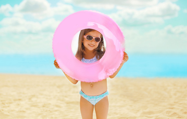 Portrait of happy child with inflatable rubber circle having fun - Fotó, kép