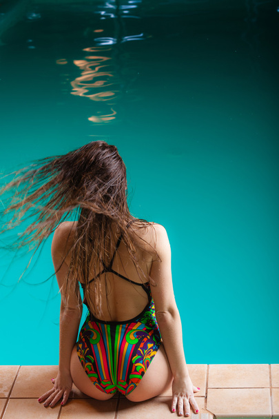 Woman back in swimsuit on pool edge. - Foto, afbeelding