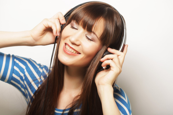 Young happy woman with headphones - Fotó, kép