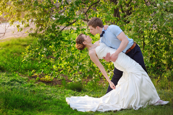 Braut und Bräutigam am Hochzeitstag beim Frühlingsspaziergang im grünen Park - Foto, Bild