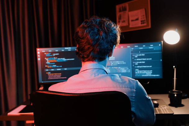Pracujący programista IT tworzący internetowe oprogramowanie deweloperskie kodowanie informacji na ekranie komputera w widoku z tyłu, myślący program dla najnowszej wersji aplikacji na stronie internetowej w nowoczesnym biurze neon. Pędziwiatr. - Zdjęcie, obraz
