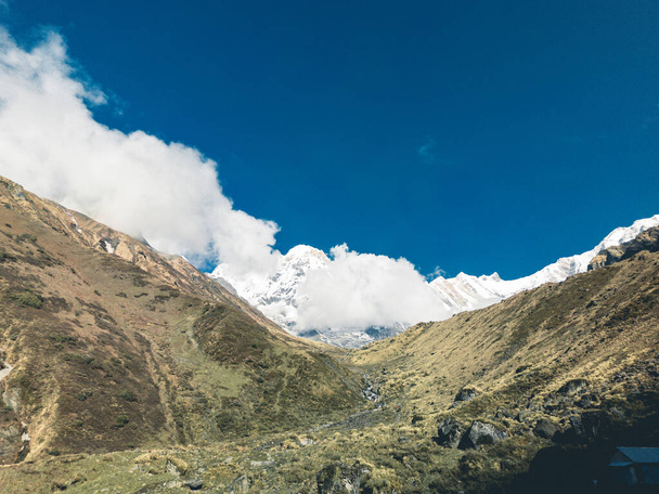 felhők a hegyek felett, hegyek a ködben, annapurna alaptábor alatt, nepal - Fotó, kép