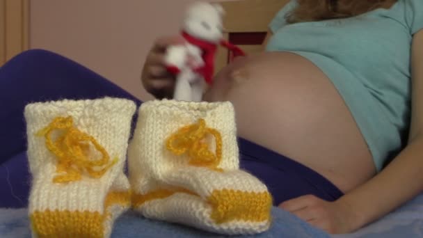 Wollschuhe für Baby und schwangere Frau Mädchen spielen mit Katzenspielzeug - Filmmaterial, Video