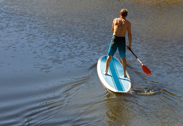 Hombre en una tabla de paddle - Foto, imagen