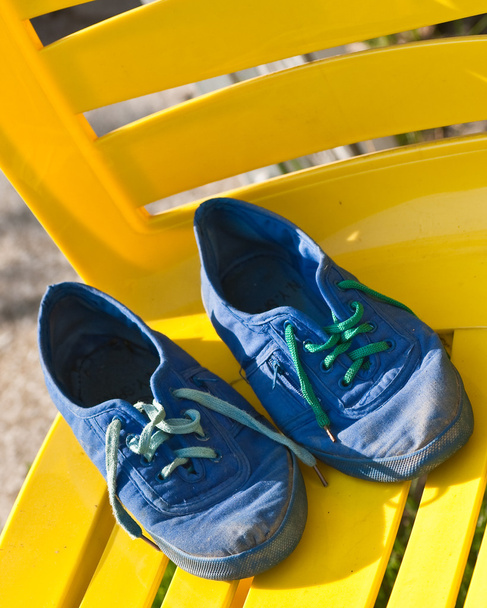 de blauwe slippers op een gele stoel - Foto, afbeelding