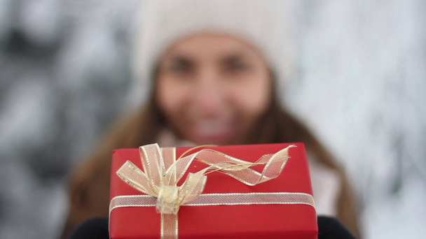 Bardzo młoda kobieta trzymając Boże Narodzenie obecny pole zimą na zewnątrz - Materiał filmowy, wideo