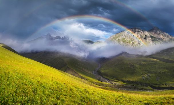 Rainbow in mountain valley during sunset - Photo, Image