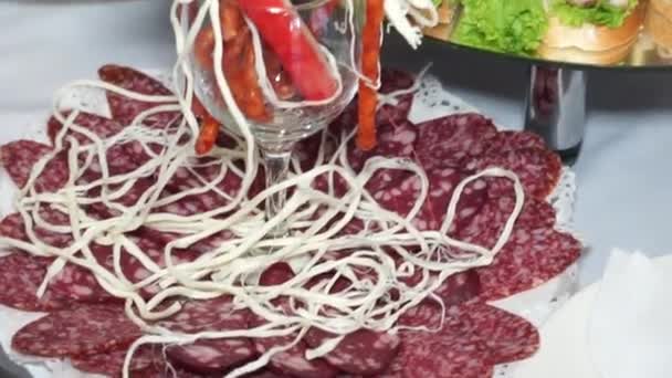 Salchichas en rodajas y sándwiches de carne en una mesa servida - Metraje, vídeo