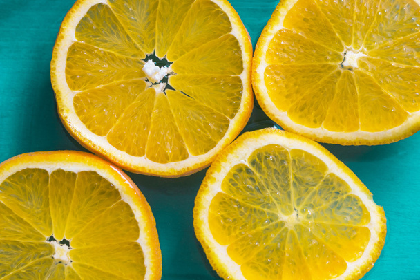 Bright slices of juicy oranges on blue background - Photo, image