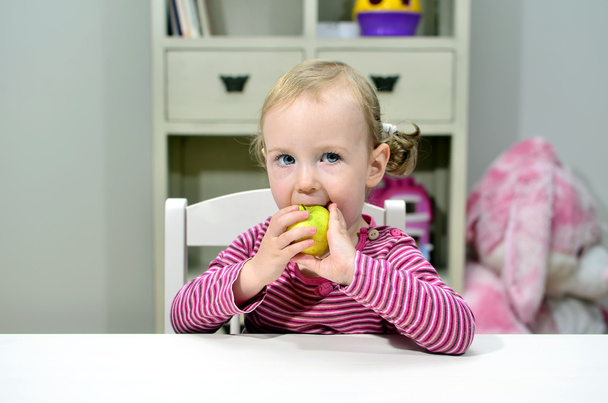 小さな女の子食べるグリーンアップル - 写真・画像