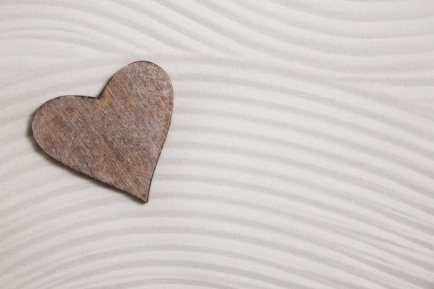 One wooden heart in the sand for a background. - Фото, зображення