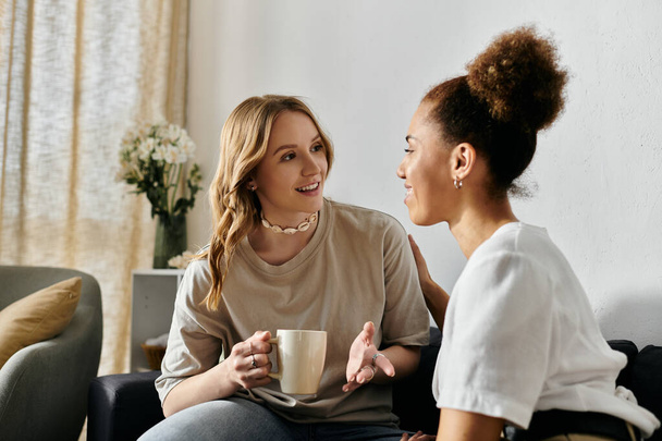 Una coppia lesbica diversificata gode di una conversazione rilassata a casa. - Foto, immagini