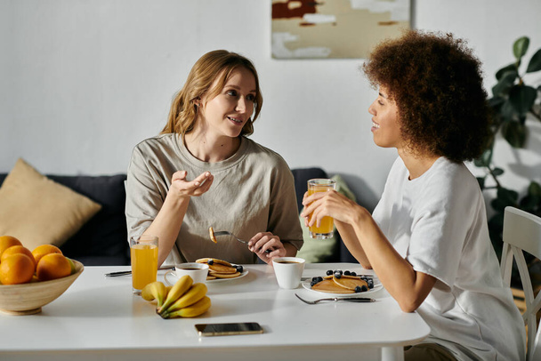 Dos mujeres disfrutan de un acogedor desayuno juntos en casa. - Foto, imagen