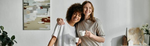 Kochająca się para lesbijek cieszy się spokojną chwilą w domu z kawą w ręku. - Zdjęcie, obraz