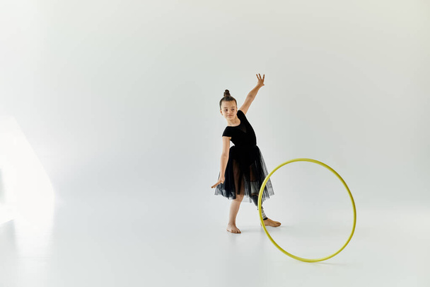 Młoda dziewczyna z protezą nogi ćwiczy gimnastykę z hula hoop w studio. - Zdjęcie, obraz