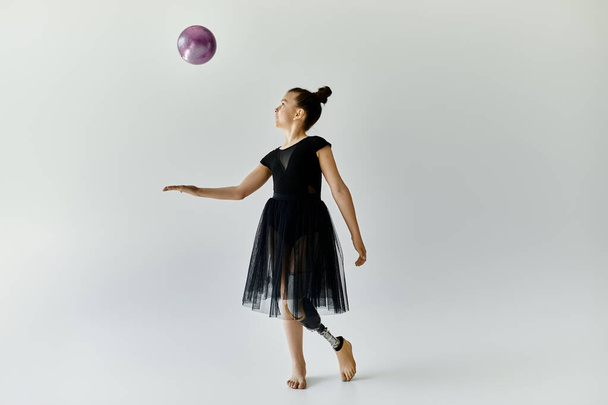 Młoda dziewczyna z protezą nogi ćwiczy gimnastykę w studio. - Zdjęcie, obraz