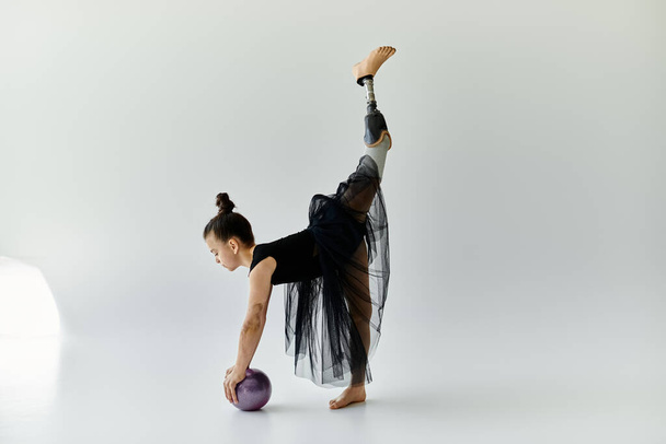 Mladá dívka s protézou nohy se elegantně protáhne během gymnastiky rutiny. - Fotografie, Obrázek
