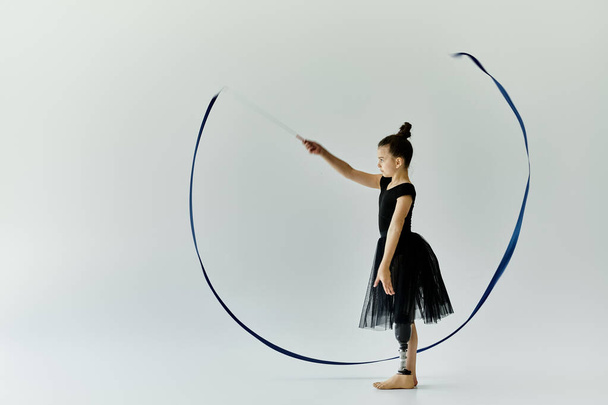 Mladá dívka s protézou nohy provádí elegantní stuhu tanec rutina. - Fotografie, Obrázek