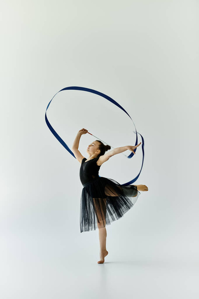 Молода дівчина з протезною ногою граціозно виконує гімнастичну рутину зі стрічкою. - Фото, зображення