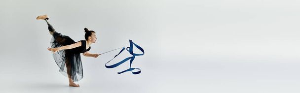 Молода дівчина з протезною ногою виконує витончену стрічкову рутину в студії гімнастики. - Фото, зображення