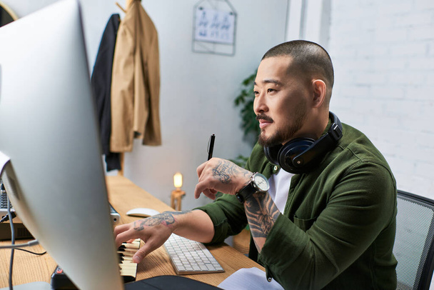 Hezký asijský muž hraje na klávesnici, zatímco pracuje na své hudební produkce ve svém studiu. - Fotografie, Obrázek