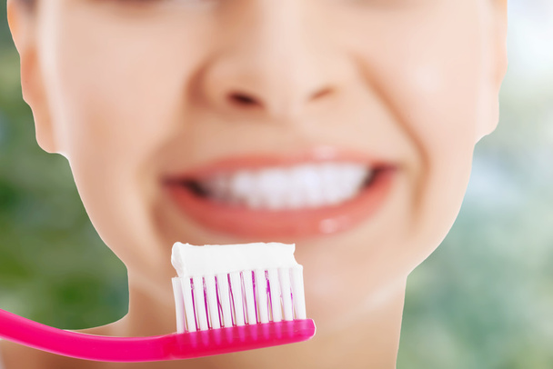 Lady holding toothbrush and smiling. - Foto, Imagem