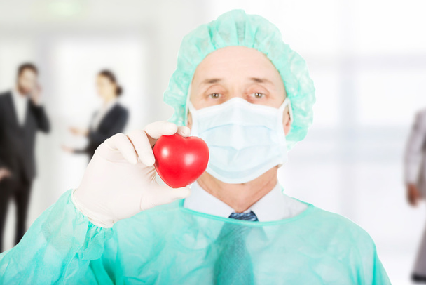 Surgeon doctor holding a heart. - Foto, afbeelding