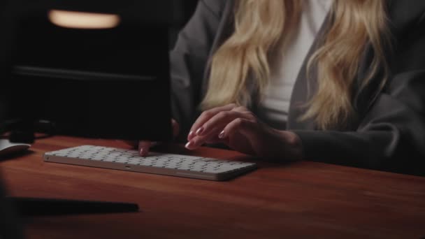 Blonďatá podnikatelka sedí na pracovišti u stolu, používá počítač a píše text na klávesnici. Koncept vzdálené práce z domova. Video z režimu natáčení bez tváře. Vysoce kvalitní 4K záběry - Záběry, video