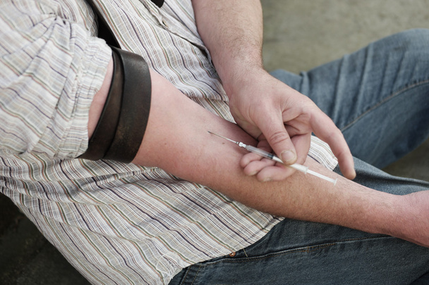 Man injecting himself with a small hypodermic - Photo, Image
