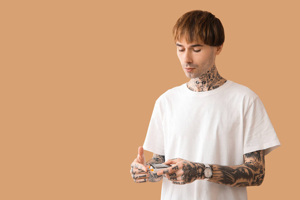Diabetico giovane uomo utilizzando glucometro su sfondo beige - Foto, immagini