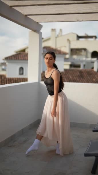 Una joven realiza con gracia ballet en una terraza al aire libre, vestida casualmente pero mostrando elegancia - Metraje, vídeo