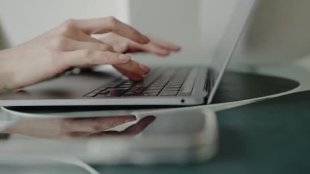 Imagen de primer plano que muestra las manos escribiendo en un teclado portátil, representando el trabajo de oficina moderno, la tecnología y la productividad. Primer plano de las manos escribiendo en el ordenador portátil en el espacio de trabajo de oficina o en casa - Metraje, vídeo