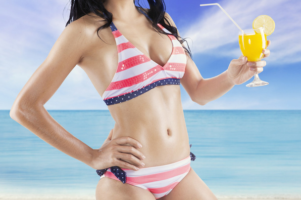 Sexy model with orange juice at shore - Foto, Imagen