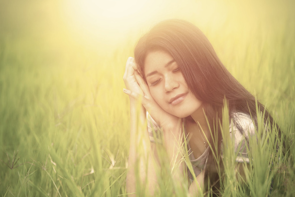 Милая женщина сидит на высокой траве
 - Фото, изображение