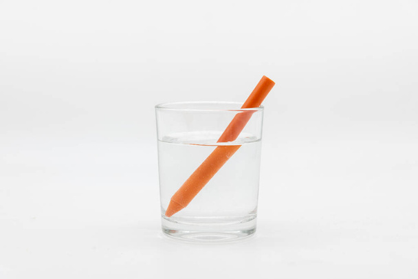 Zlomek světla, demonstrován sklenicí plnou vody s barevnými tužkami - Fotografie, Obrázek