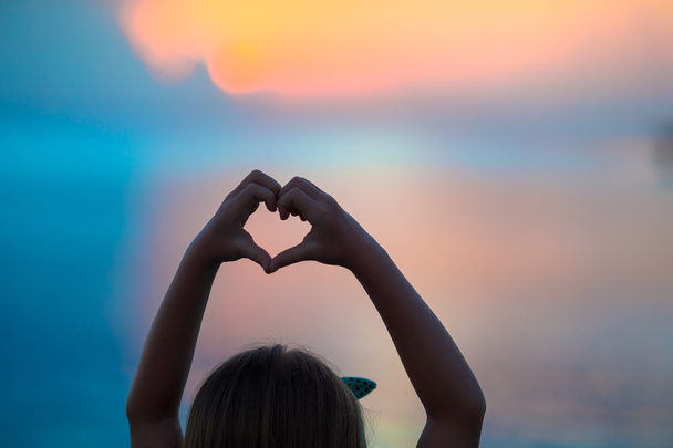 Силуэт сердца, сделанный детской рукой на закате
 - Фото, изображение