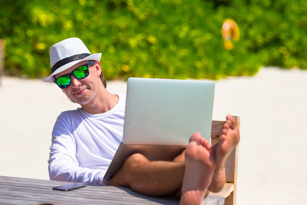 Νεαρός άνδρας με tablet υπολογιστή κατά τη διάρκεια τροπικών διακοπές παραλία - Φωτογραφία, εικόνα