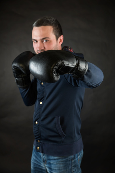 Handsome man with black boxing gloves. A concept of a challenge. - Photo, Image