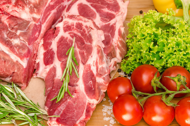 Сире м'ясо з овочами та спеціями на дерев'яному фоні
 - Фото, зображення